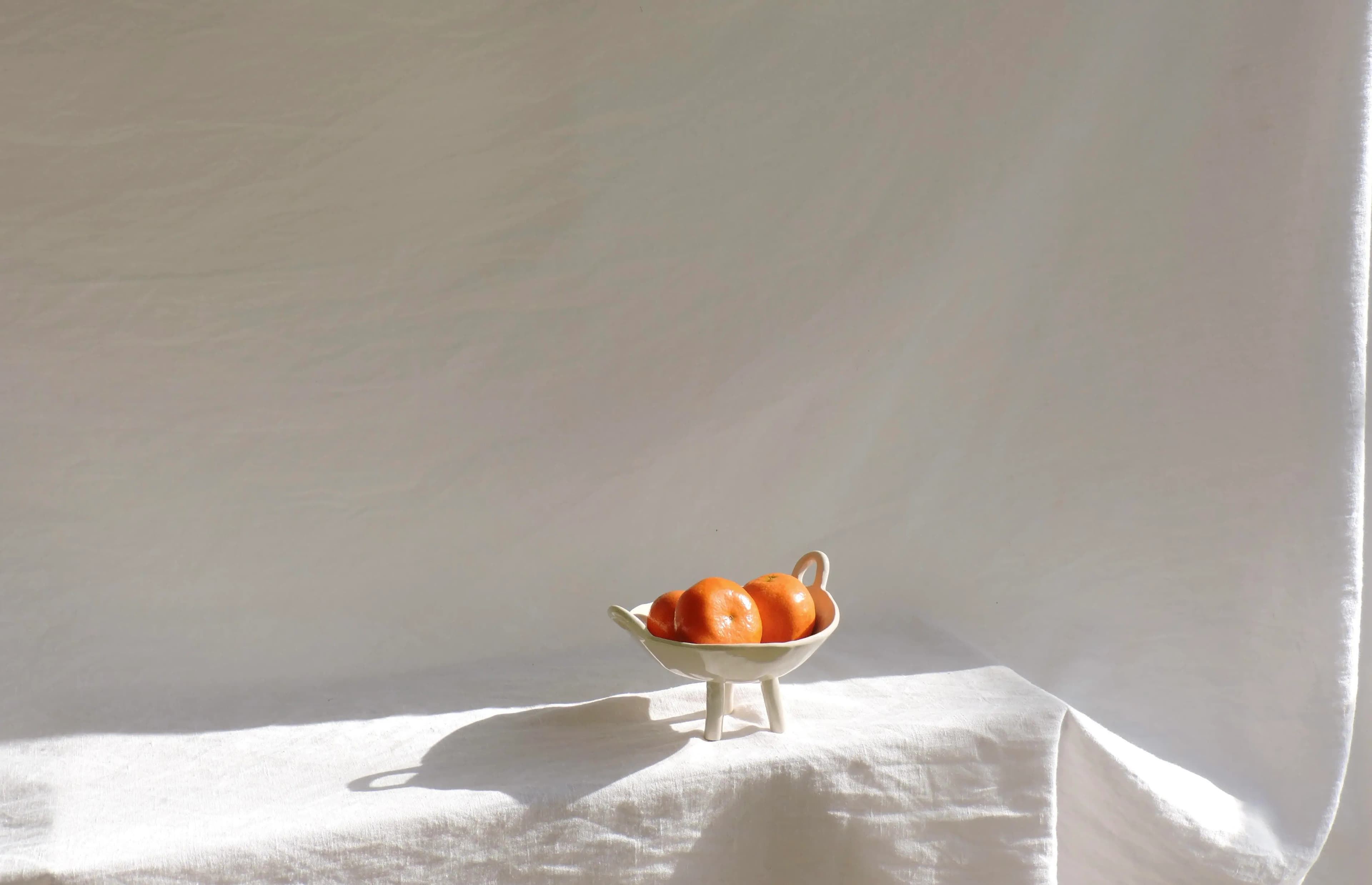 Frutero de cerámica artesanal con naranjas dentro, pieza única de Tāra